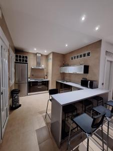 een grote keuken met een aanrecht en stoelen. bij Vista Noguera in Huéscar