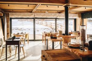 a restaurant with tables and chairs and a large window at Les Chalets de Pierrot in Cogne