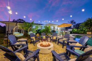 a backyard with chairs and a fire pit and a pool at Resort Style Backyard Pool Hot Tub Games in Seminole