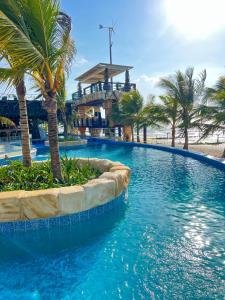 a large swimming pool with palm trees and a beach at Casa Luna Laguna Beach in Tolú
