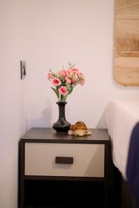 een vaas met bloemen op een tafel naast een bed bij Seaside Serenity Resort in Hiriketiya +3 foto's