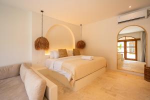 een slaapkamer met een bed, een bank en een spiegel bij Luna Kai Villas in Uluwatu +44 foto's