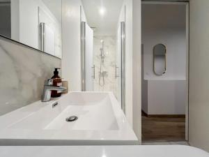 a white bathroom with a sink and a shower at appartement t2 la doutre 2-4 personnes in Angers