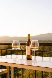 Una botella de vino y dos copas en una mesa en Acherontas Rooms 1, en Vouvopótamos