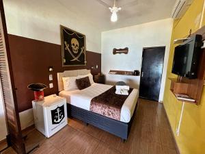 een slaapkamer met een bed en een flatscreen-tv bij Mirante do Pirata in Ubatuba