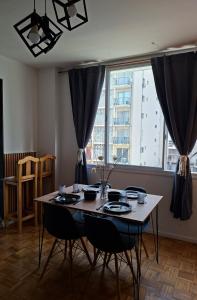 een eettafel met stoelen en een groot raam bij kirahome in Buenos Aires