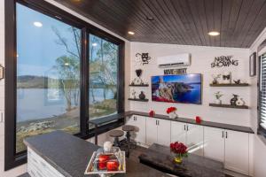 a kitchen with white walls and a large window at Black Tie Affair - Eloquent Riverfront Experience in New Richmond
