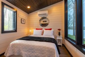 a bedroom with a bed in a room with windows at Black Tie Affair - Eloquent Riverfront Experience in New Richmond