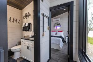 a small bathroom with a bed and a toilet at Black Tie Affair - Eloquent Riverfront Experience in New Richmond +84 photos