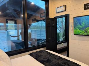 a bedroom with a view of a living room with windows at Black Tie Affair - Eloquent Riverfront Experience in New Richmond