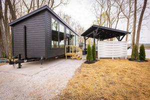 a black tiny house sitting on top of a field at Black Tie Affair - Eloquent Riverfront Experience in New Richmond