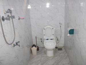 un baño con inodoro y ducha en Lexus Guest House, Kasangati, en Kampala