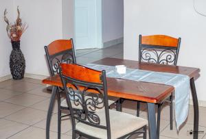 a dining room table with two chairs and a vase at Emmanuel Guesthouse in eMalahleni