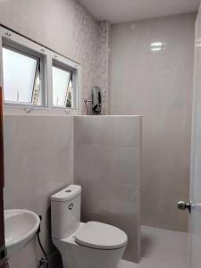 a white bathroom with a toilet and a sink at Huan Janto Homestay - Nimmanaradee in Ban Sam Lang
