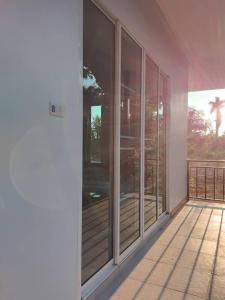 an empty balcony with glass doors on a house at Huan Janto Homestay - Nimmanaradee in Ban Sam Lang