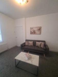 ein Wohnzimmer mit einer Couch und einem Couchtisch in der Unterkunft Cosy 3 bed House South Shields in Jarrow