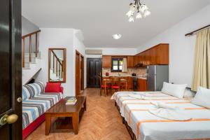 a hotel room with two beds and a table at Mandraki Paradise in Meyisti