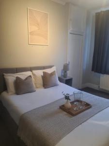 ein Schlafzimmer mit einem weißen Bett und einem Tablett darauf in der Unterkunft City North Apartment in Longbenton