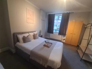 ein Schlafzimmer mit einem großen weißen Bett und einem Tablett darauf in der Unterkunft City North Apartment in Longbenton