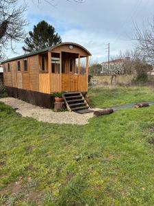 una piccola cabina in legno in un prato di La Roulotte Saintaise a Saintes