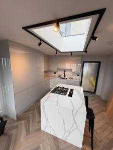 a kitchen with a white counter and a skylight at The New 2 Plas Morolwg in Aberystwyth +21 photos