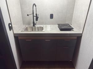 a kitchen counter with a sink in a room at Suite Ipê in Gramado