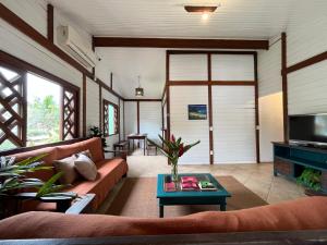 een woonkamer met een bank en een tafel bij Pousada Nalu - Camburi in São Sebastião