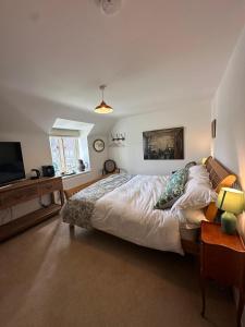 アシュボーンにあるOverfield Farmのベッドと薄型テレビのある寝室