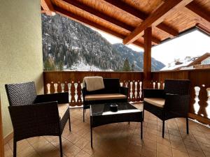 a balcony with chairs and a table with a mountain view at Cèsa Nicole e Patrick in Campitello di Fassa