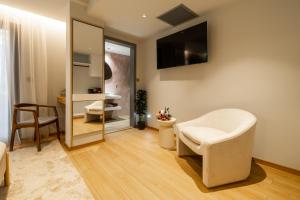 ein Wohnzimmer mit einem Stuhl und einem Spiegel in der Unterkunft Aria Stay in Drama