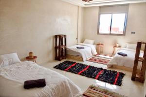 a bedroom with two beds and a window at Cool Surfers in Tamraght Ouzdar