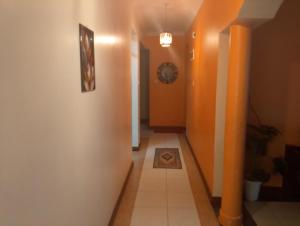 Un pasillo con paredes naranjas y suelo de baldosas. en Royal D8, en Mombasa 1 foto más