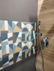 uma casa de banho com uma parede de azulejos e um chuveiro em Garden Relax Suites em Ispica