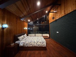 een slaapkamer met een bed en een bakstenen muur bij Meraki Cottage in Darjeeling