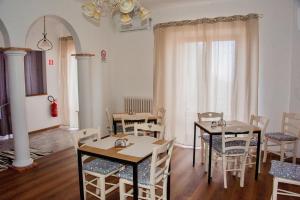 a dining room with tables and chairs and a window at Paradise B&B in Panicarola