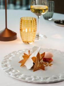 a plate of food on a table with a glass of wine at Grand Hotel Courmayeur Mont Blanc, by R Collection Hotels in Courmayeur