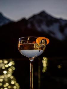 a glass of wine with an orange slice in it at Grand Hotel Courmayeur Mont Blanc, by R Collection Hotels in Courmayeur