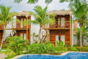 a resort with a swimming pool and palm trees at Villa Jaguar Fortim in Fortim