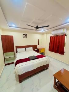 a bedroom with a large bed and a table at RI Krishna Residency in Visakhapatnam
