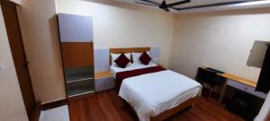 a small room with two beds and a tv at RI Krishna Residency in Visakhapatnam +2 photos