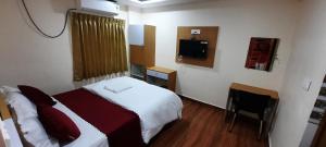 a hotel room with a bed and a television at RI Krishna Residency in Visakhapatnam