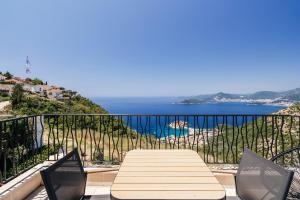 a table and chairs on a balcony with a view of the ocean at The View - Apartment with Pool in Blizikuće