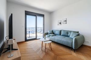 a living room with a blue couch and a table at The View - Apartment with Pool in Blizikuće