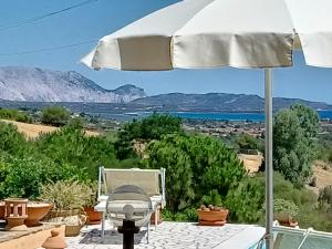 a white umbrella sitting on a patio with a view at Li Muntigeddi in San Teodoro