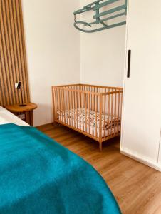 a bedroom with a crib and a door to a room at Nad Soutokem in Volary