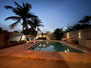 a swimming pool with a chair next to a house at Pousada Areia in Saquarema +47 photos