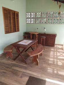 einen Holztisch und eine Bank in einem Zimmer in der Unterkunft Quintal dos Pinheiros in Pirenópolis