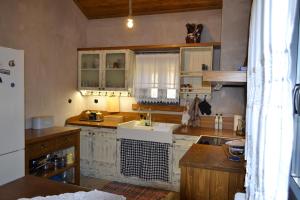 une cuisine avec des armoires blanches et un évier dans l'établissement AMPELOPETRA - Slow Country Living, à Ioannina 50 autres photos