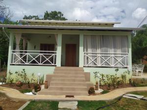 ein kleines grünes Haus mit Treppe davor in der Unterkunft Quintal dos Pinheiros in Pirenópolis