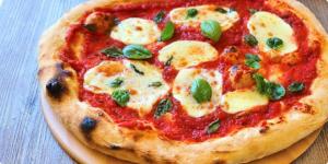 a pizza sitting on top of a plate on a table at Palazzo Maiori in Torre Annunziata +30 photos